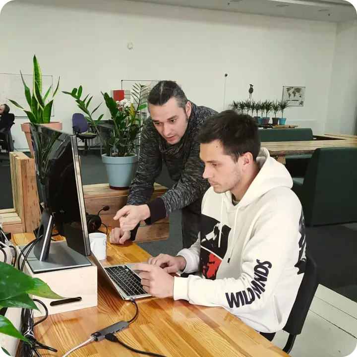 Two men collaborating at a computer.